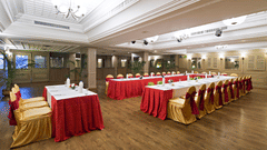 A banquet hall is set up for a celebration with tables and chairs draped in red and gold fabric - Clarks Avadh, Lucknow