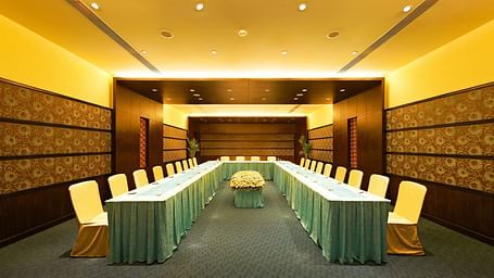 Modern conference room with a U-shaped table and comfortable seating at GRT Hotels