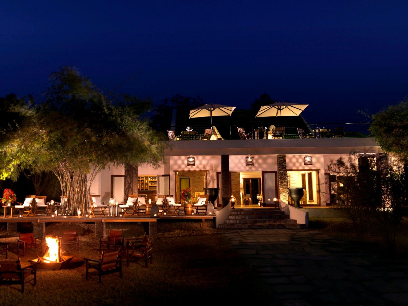 exterior facade with lights on inside the resort during the night - our resort in Kabini