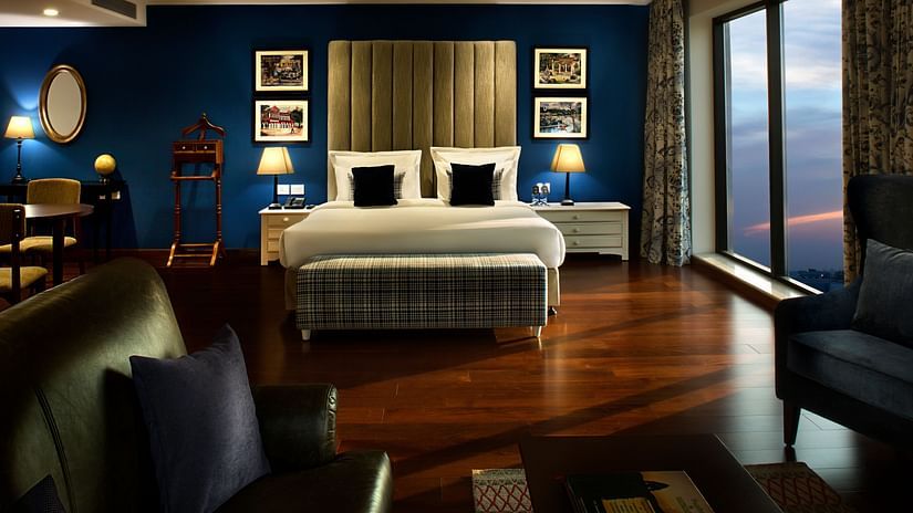 king size bed with floor-to-ceiling windows overlooking the city