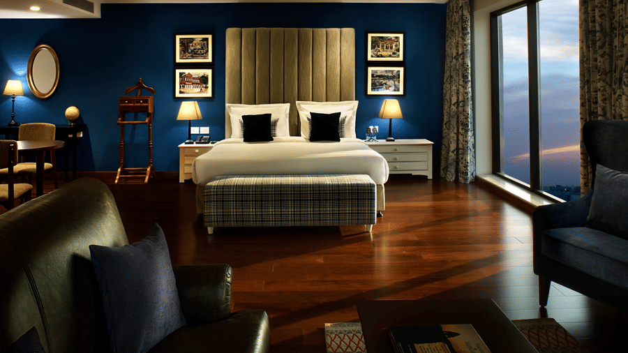 king size bed with floor-to-ceiling windows overlooking the city