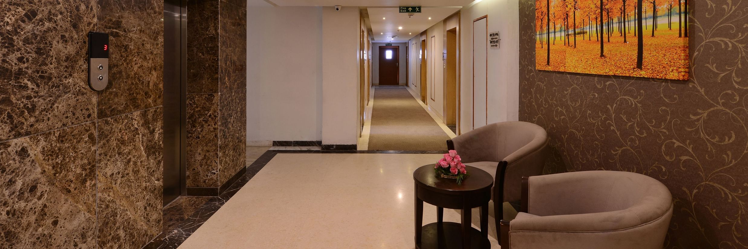 Image of a hotel gallery with sofa chairs and table