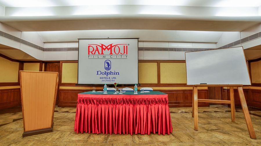 A presentation area in a hotel conference room with a podium and red tablecloth. - Tara, Comfort Hotel in Hyderabad - Ramoji Film City.