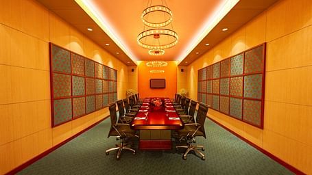 Luxury conference room with a long table, chandeliers, and warm lighting at GRT Hotel