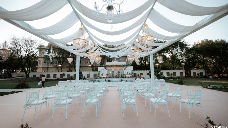 Wedding seating arrangement under a draped canopy setup at Umaid Palace lawn.