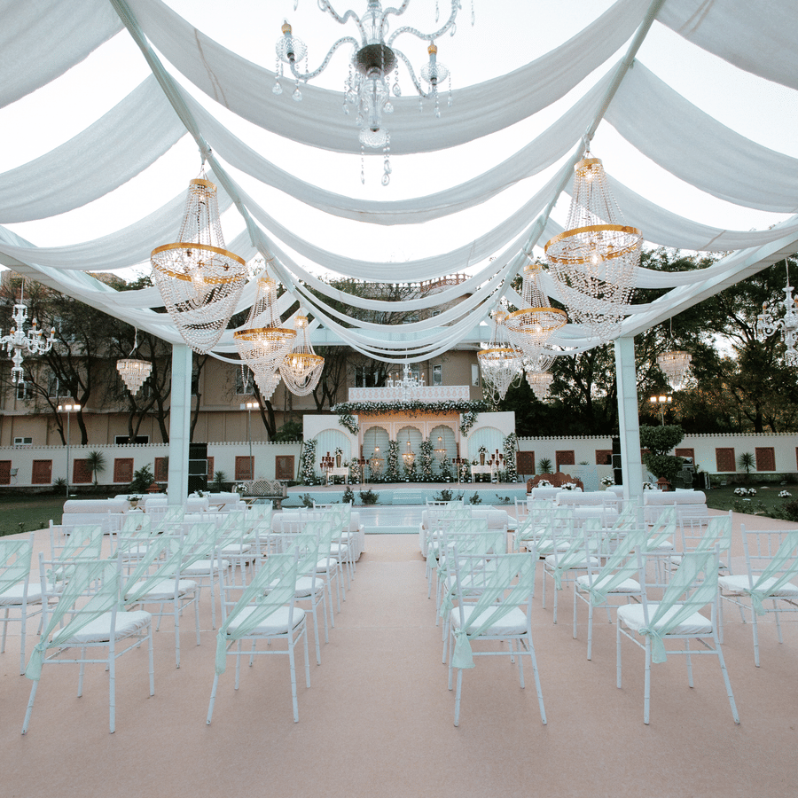 Wedding seating arrangement under a draped canopy setup at Umaid Palace lawn.