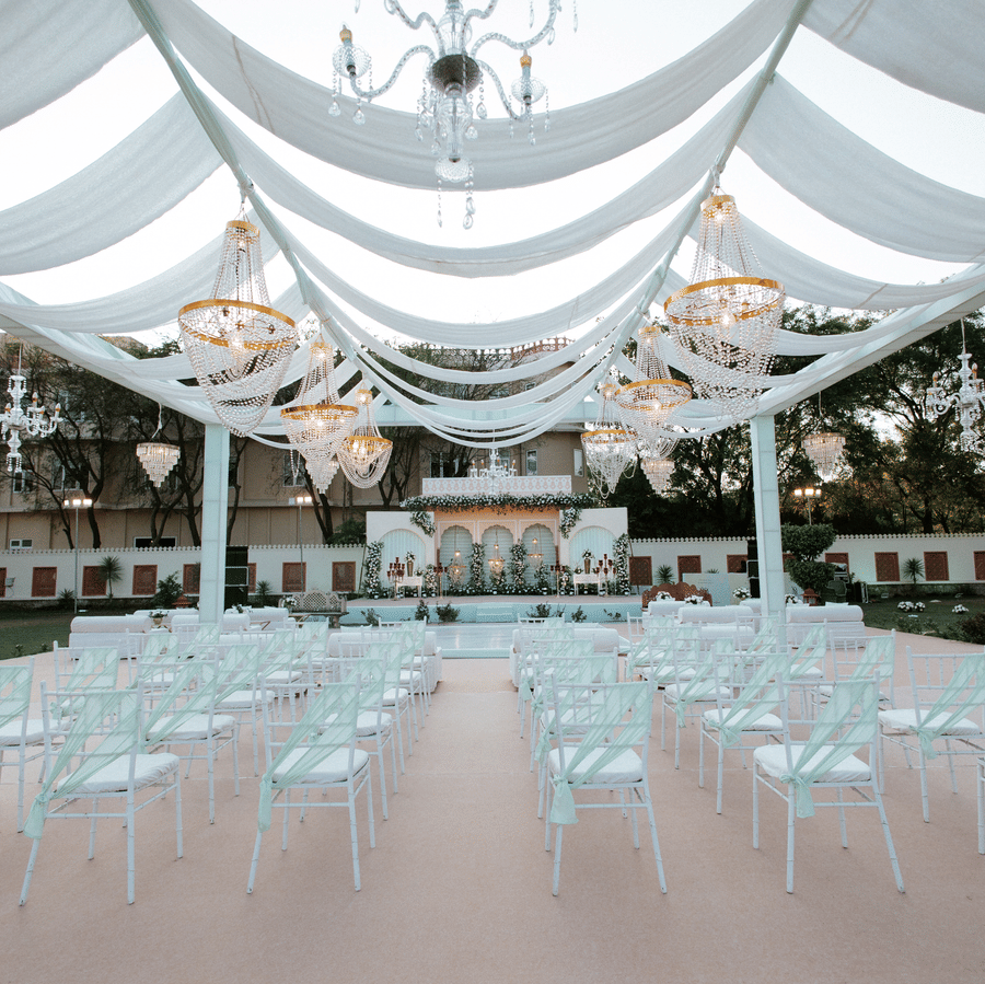 Wedding seating arrangement under a draped canopy setup at Umaid Palace lawn.