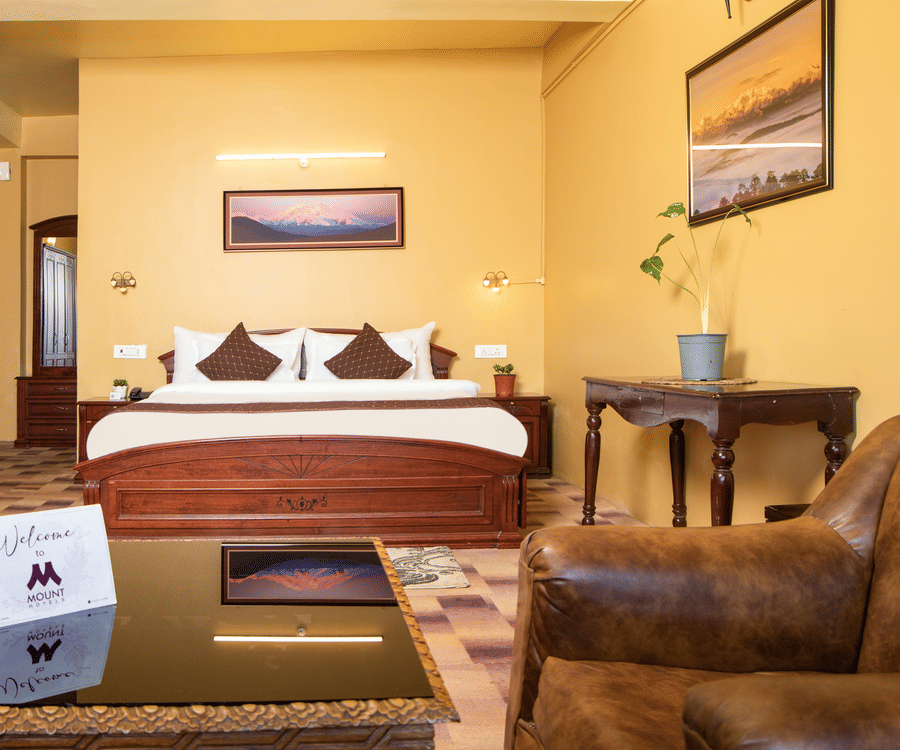 Comfortable hotel room with bed, chairs, and ambient warm lighting.