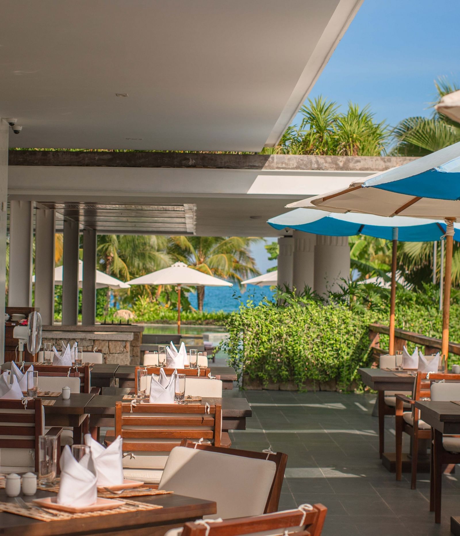 An outdoor seating at our restaurant with parasols - Alibu Resort Nha Trang