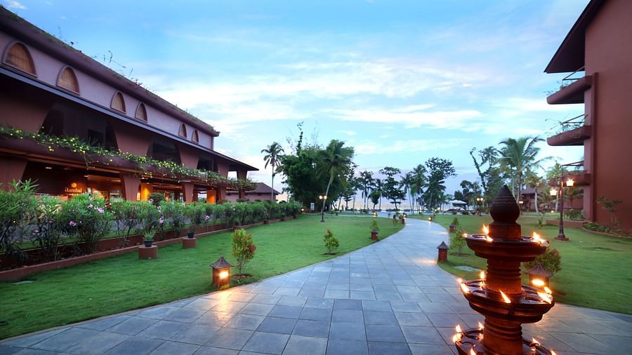 A walkway through the lawn at Uday Backwater Resort featuring diyas lit up on the side