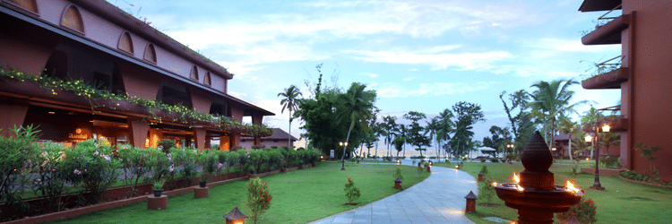 A walkway through the lawn at Uday Backwater Resort featuring diyas lit up on the side