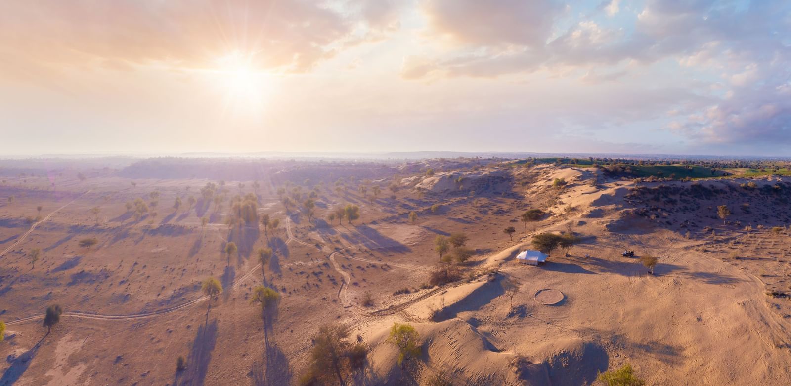 The campsite is seen from a higher altitude, showing the isolated and tranquil setting among the gentle desert terrain - MANVAR Resort & Desert Camp