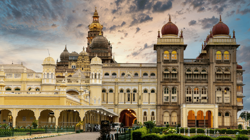 Facade of Mysore Palace with its towering dome-like structures under a vibrat sky