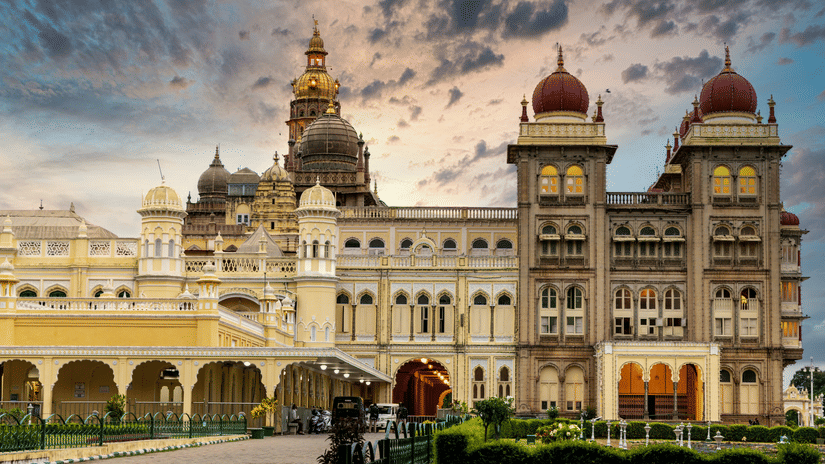 Facade of Mysore Palace with its towering dome-like structures under a vibrat sky