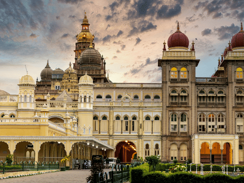 Facade of Mysore Palace with its towering dome-like structures under a vibrat sky