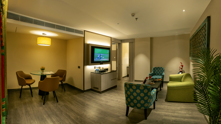 Comfortable suite with lounge seating, work desk and warm lighting at The Sonnet, Jamshedpur.