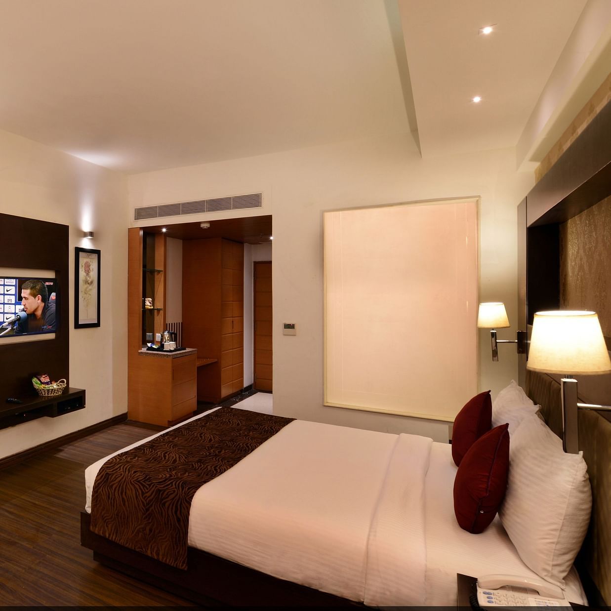 Image of executive suites with a large bed, TV, chair and a table