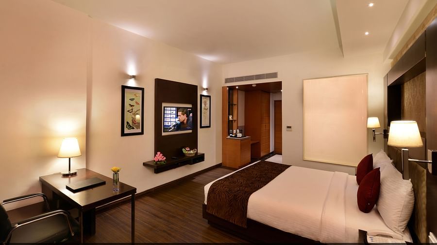 Image of executive suites with a large bed, TV, chair and a table