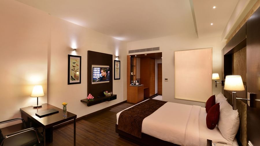 Image of executive suites with a large bed, TV, chair and a table
