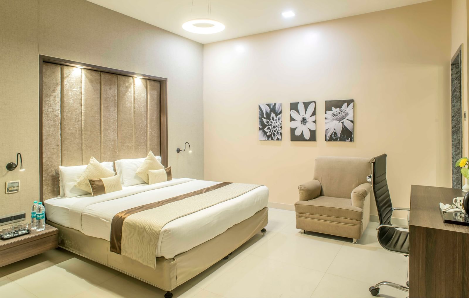 Bright hotel room with a king size bed, a sitting area, and decorative wall art | The Citi Residenci Hotel Durgapur