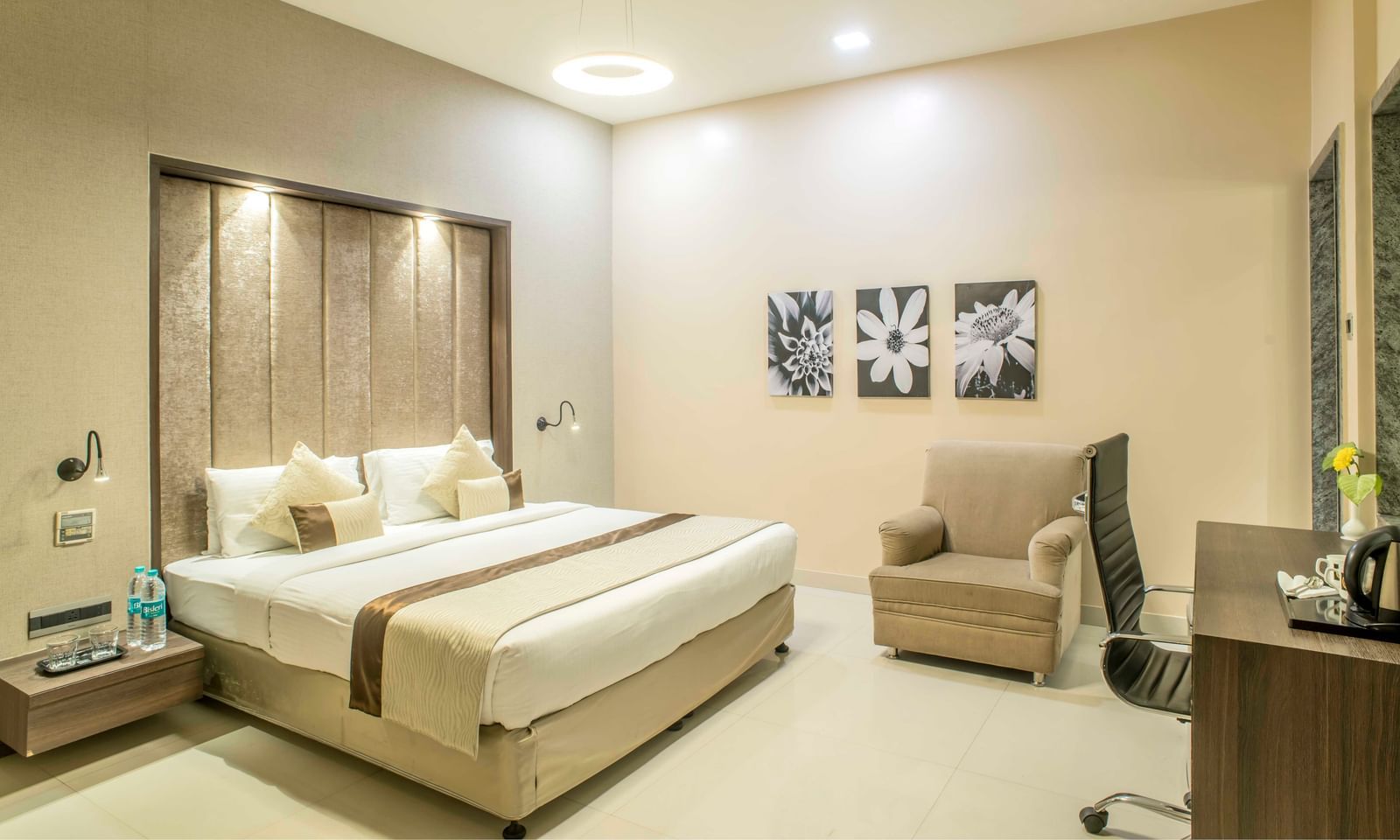 Bright hotel room with a king size bed, a sitting area, and decorative wall art | The Citi Residenci Hotel Durgapur