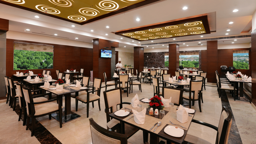 Restaurant with tables and chairs arranged with ceiling lights