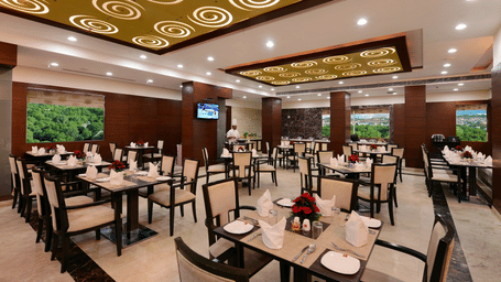 Restaurant with tables and chairs arranged with ceiling lights