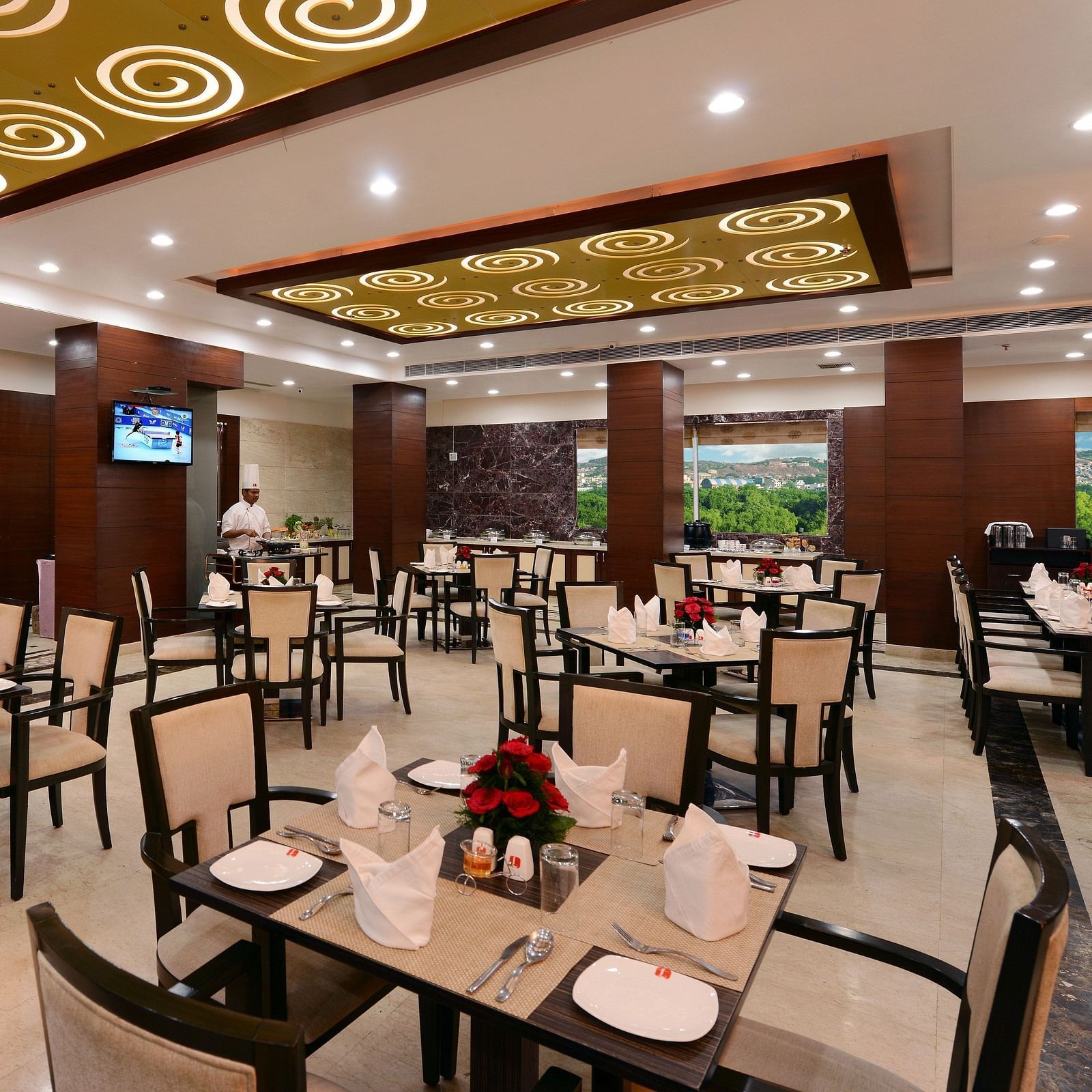 Restaurant with tables and chairs arranged with ceiling lights