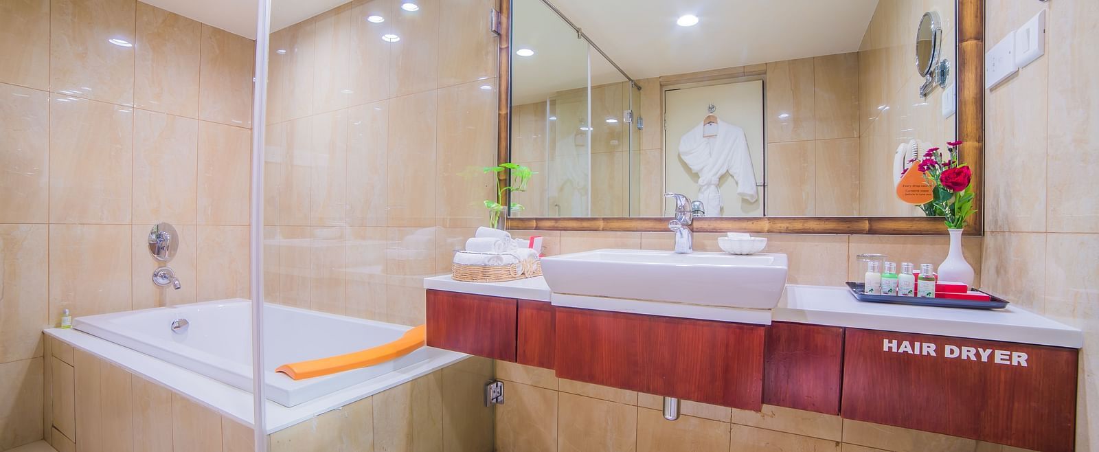 An elegant hotel bathroom featuring a bathtub, modern fixtures, and marble accents A grand hotel suite with an opulent red and white decor, large bed, and seating area, reflecting a traditional style at Sitara Luxury Hotel in Hyderabad near Ramoji Film Cit