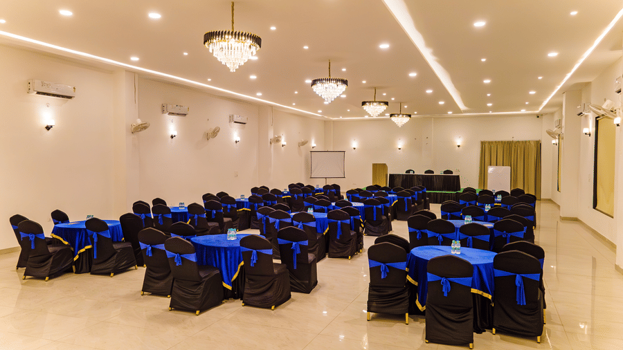 Mystic Jungle Hall at Vedikant Resorts The Mallard Corbett featuring a huge banquet hall with several sets of tables and chairs, chandeliers, air-conditioners, white boards and screens, a podium, and more.
