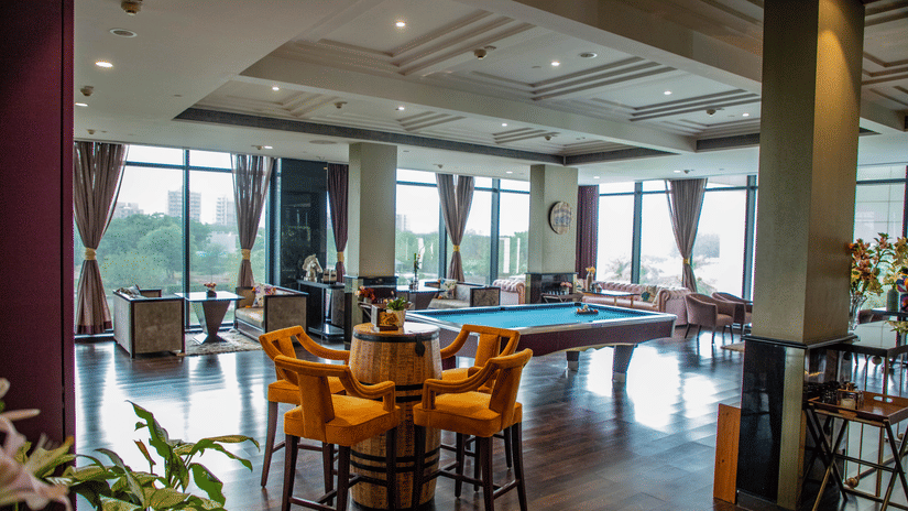 Seating arrangements inside a restaurant with a pool table in view at Karma Lakelands.