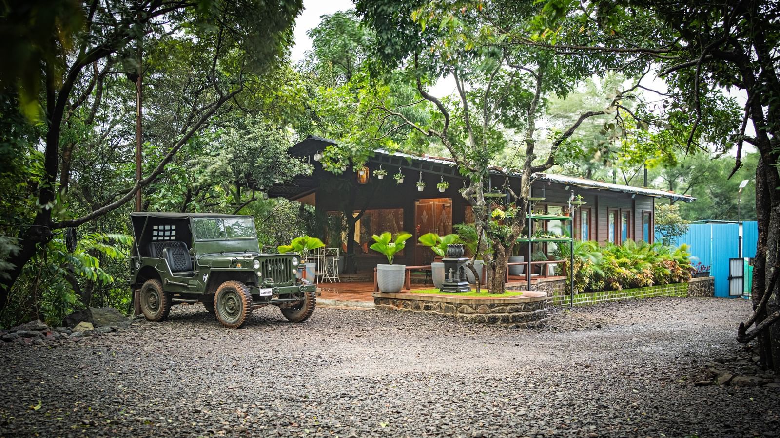 A military jeep parked on a gravel driveway in front of a modern building with a covered walkway - Tranquil Piedmont Estates & Resort