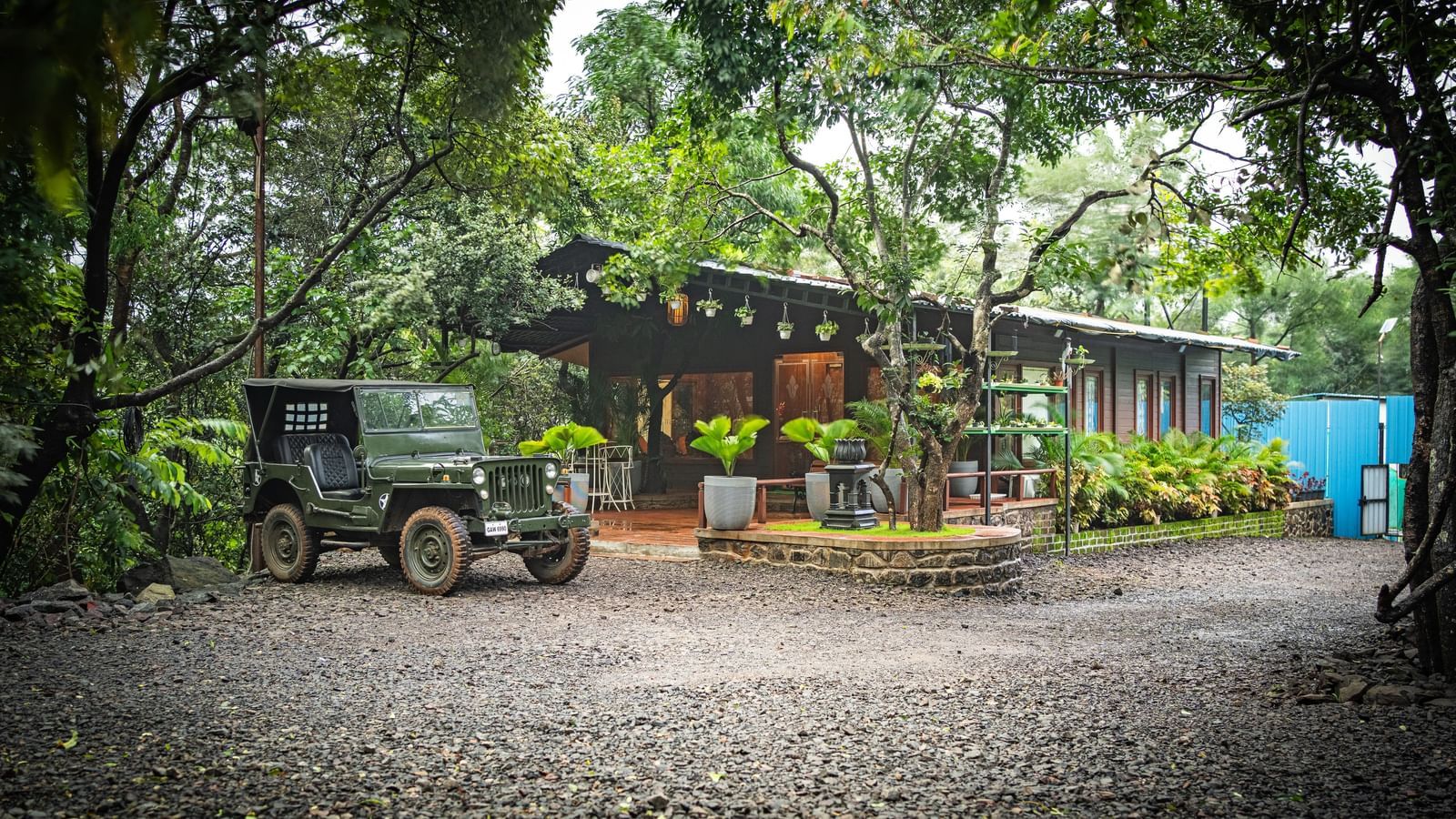 A military jeep parked on a gravel driveway in front of a modern building with a covered walkway - Tranquil Piedmont Estates & Resort