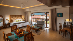 Lounge Suite at Uday Samudra Leisure Beach Hotel featuring a king bed, dining table with fruit, seating area, desk, and a balcony with a view