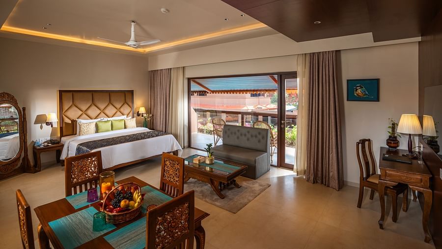 Lounge Suite at Uday Samudra Leisure Beach Hotel featuring a king bed, dining table with fruit, seating area, desk, and a balcony with a view