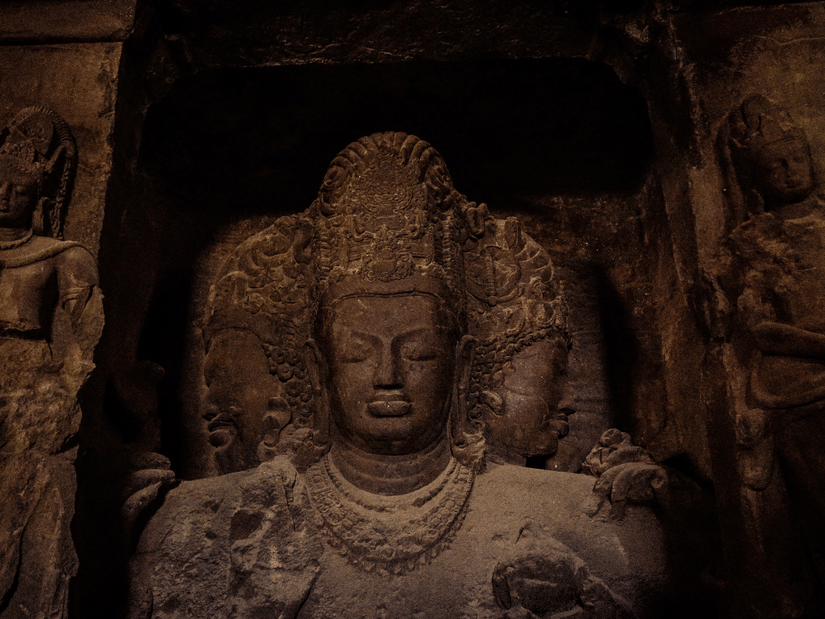 Ancient stone carvings of Hindu deities at the Elephanta Caves, a UNESCO World Heritage Site near Mumbai, India.