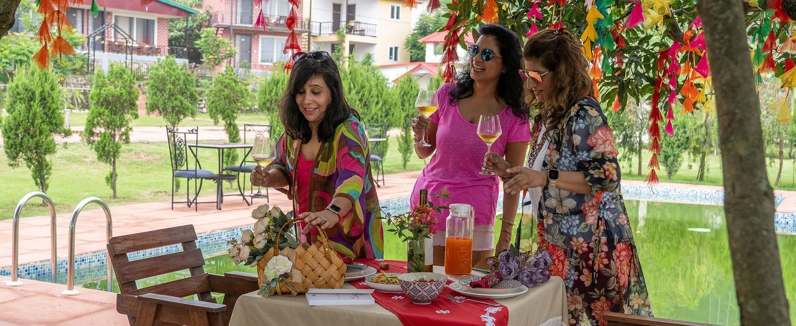 a group of women talking while holding their glass of beverage - neer ganga Resorts