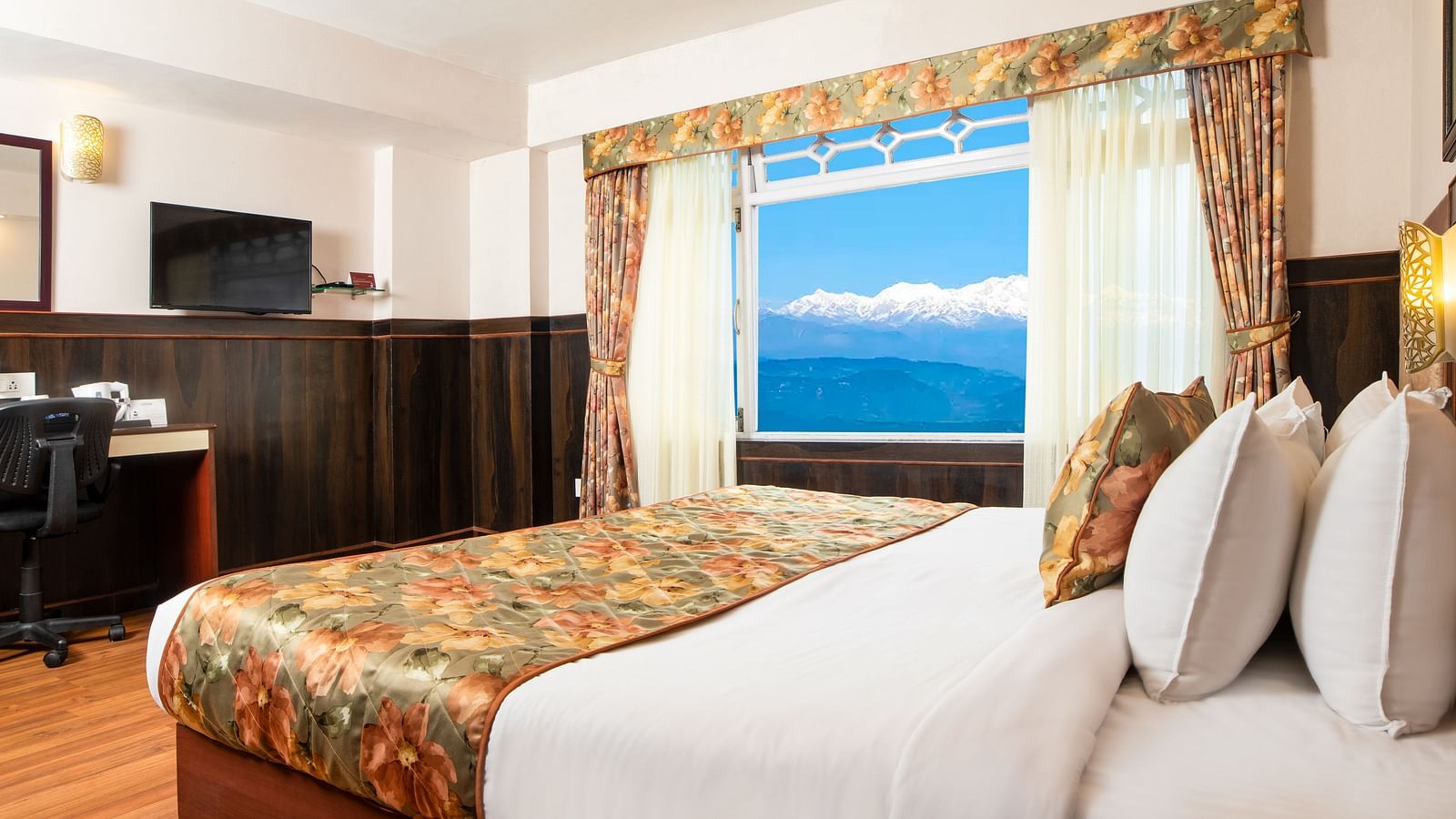 A side view of a bed in a room that has a glass window and TV on the wall | Summit Oakden Resort & Spa, Mall Road
