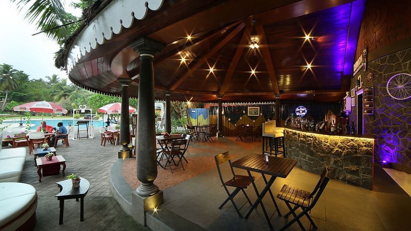 Reunion, the Gastropub at  Uday Samudra Leisure Beach Hotel illuminated with warm and purple lights by the pool