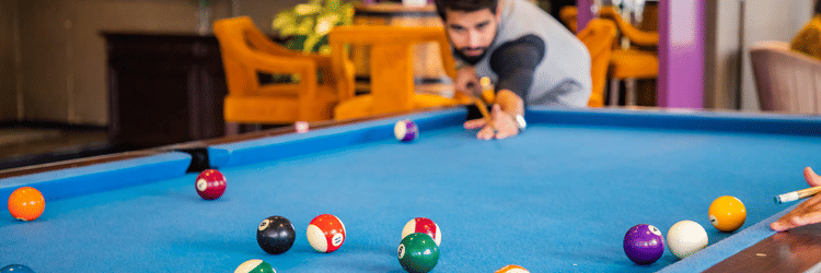 A guest playing pool at AKs Cocktail Bar - Karma Lakelands.