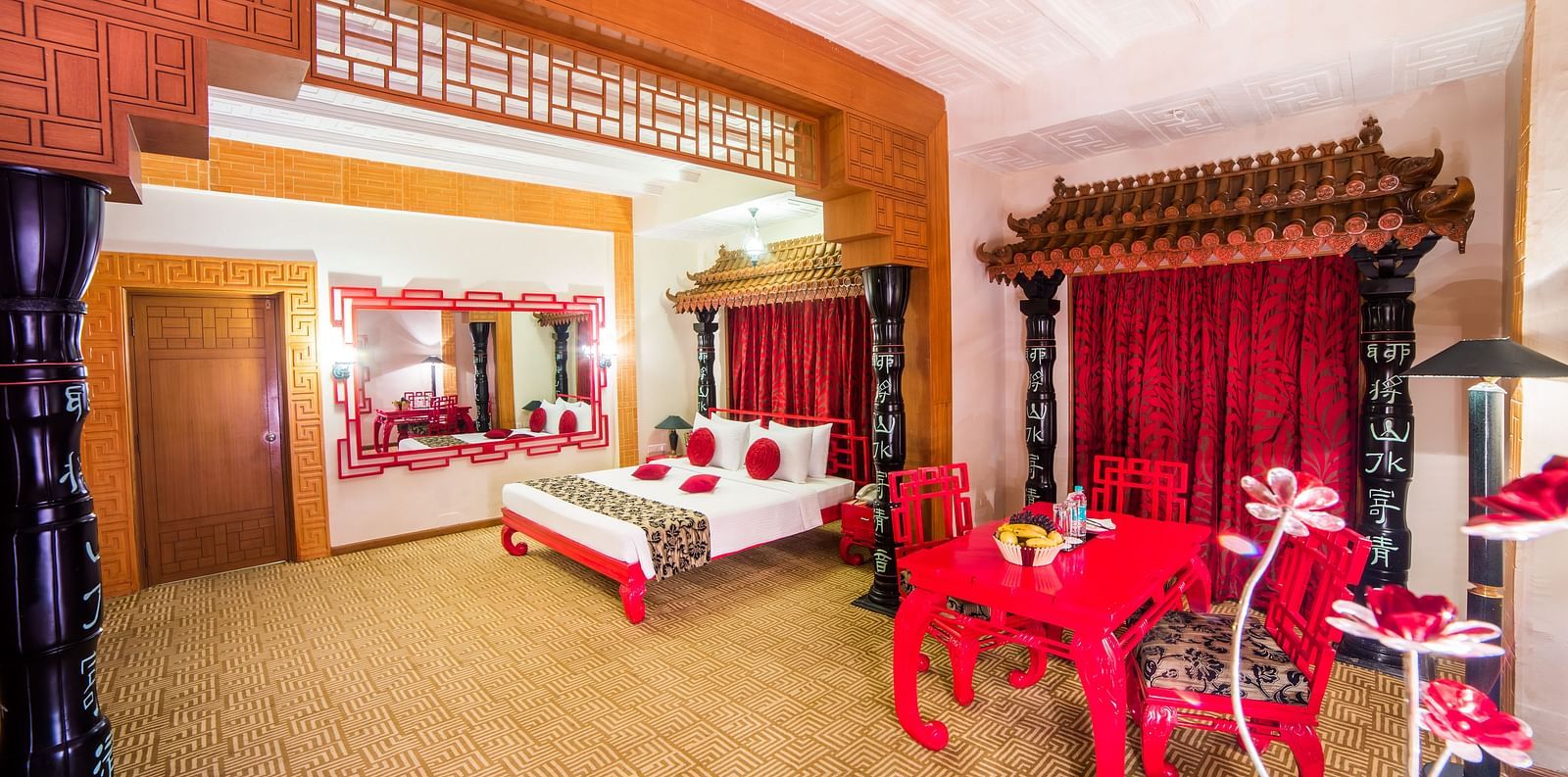 A luxurious red and white themed hotel suite with traditional furnishings and a festive atmosphere at Sitara Luxury Hotel in Hyderabad near Ramoji Film City.