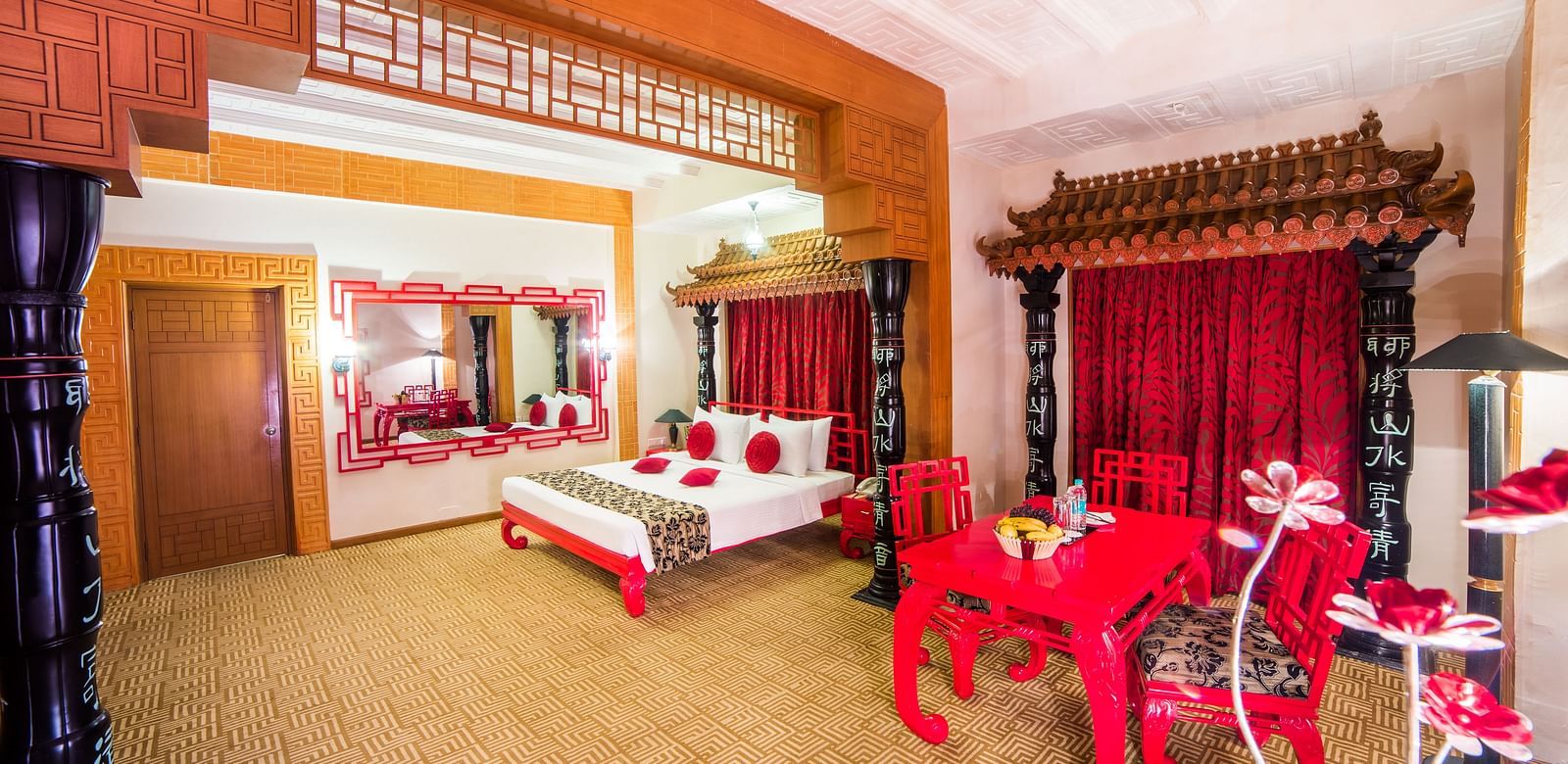 A luxurious red and white themed hotel suite with traditional furnishings and a festive atmosphere at Sitara Luxury Hotel in Hyderabad near Ramoji Film City.