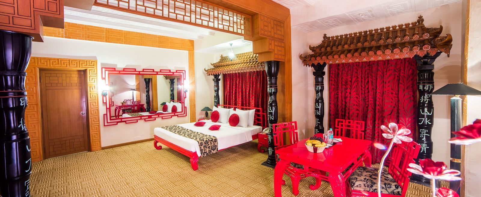 A luxurious red and white themed hotel suite with traditional furnishings and a festive atmosphere at Sitara Luxury Hotel in Hyderabad near Ramoji Film City.