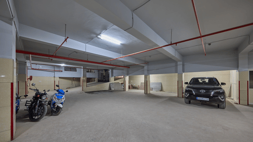 Parking area with a car and few bikes parked at Grand Continent - A Sarovar Premiere Affiliate Hotel, Hosur