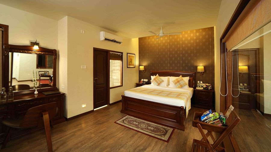 The Grand Family Suite at Uday Samudra Leisure Beach Hotel, Kovalam, features a bedroom with a king size bed, a desk, and a balcony.