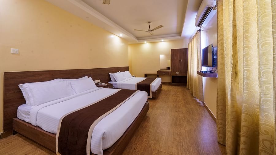 Side view of spacious room with two beds and modern amenities at Wyt Hotels, Rameswaram