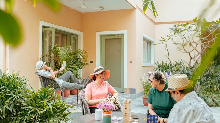 Guests seated on an outdoor patio with plants and furniture at Karma Chalets.