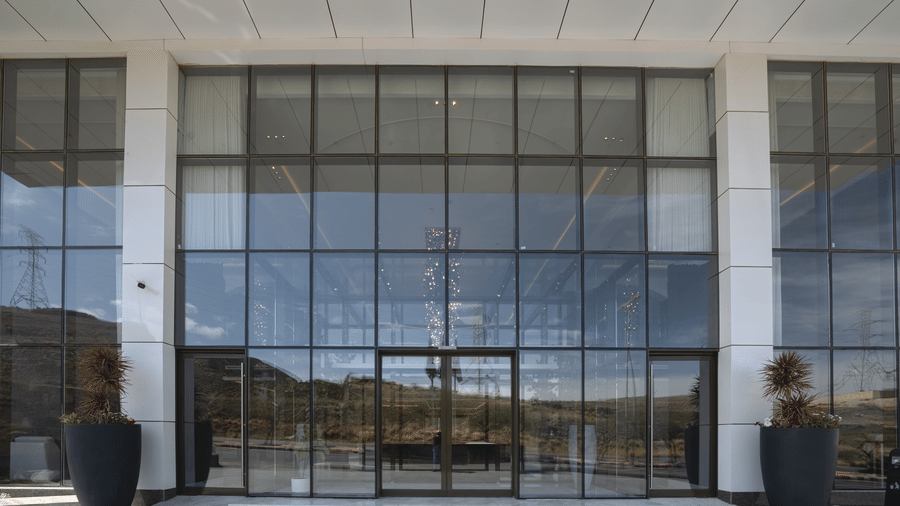 The lobby and entrance of Grand Iva Hotel, Abha, seen through large glass windows with panelling.