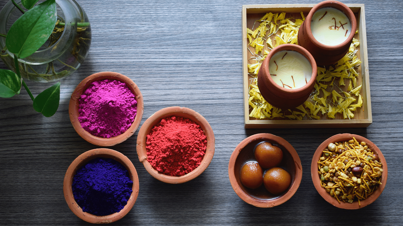 Holi colours with Gulab Jamun, mixture and thandai kept separately in a clay pot