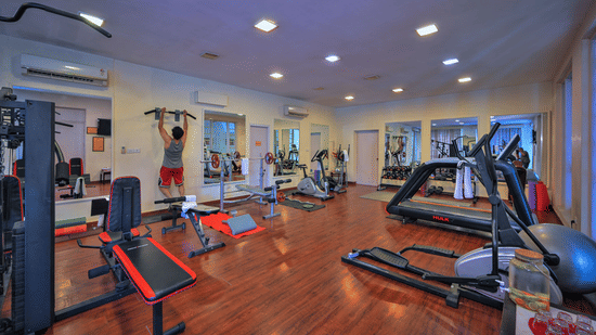 A gym area with treadmills, mirrors, and other gym equipments placed at The Clarks Varanasi.